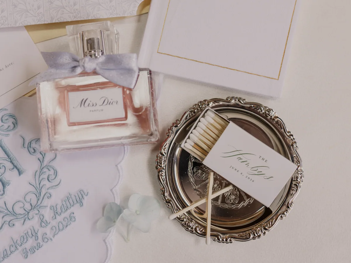 An invitation suite, a ring dish and a bottle of scent
