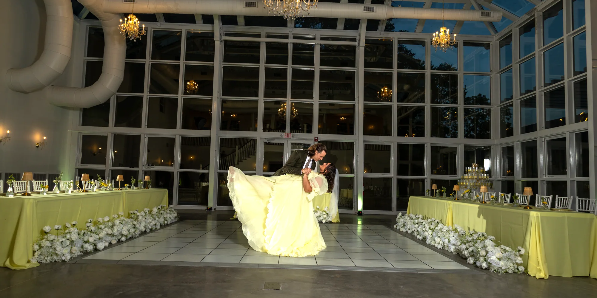 The conservatory at Magnolia House lit for a reception, a couple dancing under the chandeliers