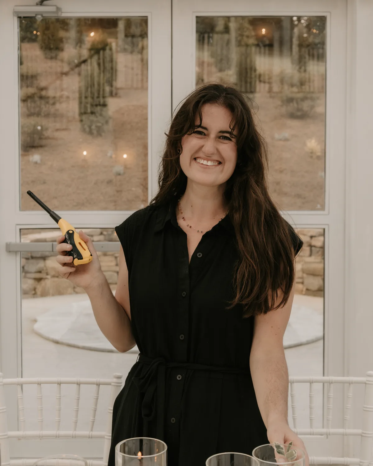 Kobi Cummings, smiling, lighting candles on a reception table
