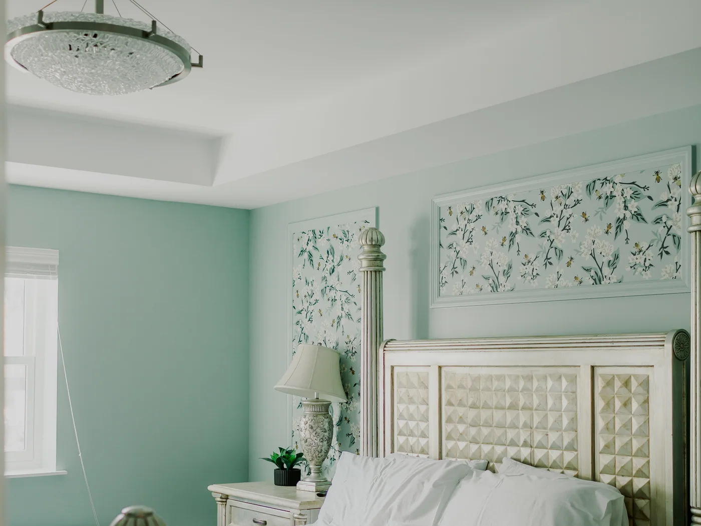 The primary suite, a king bed under a carved headboard