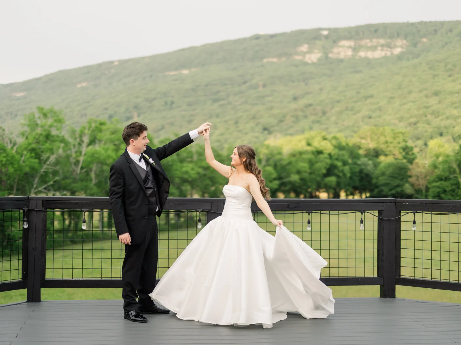 A couple dancing on the Lookout Deck, the ridge behind