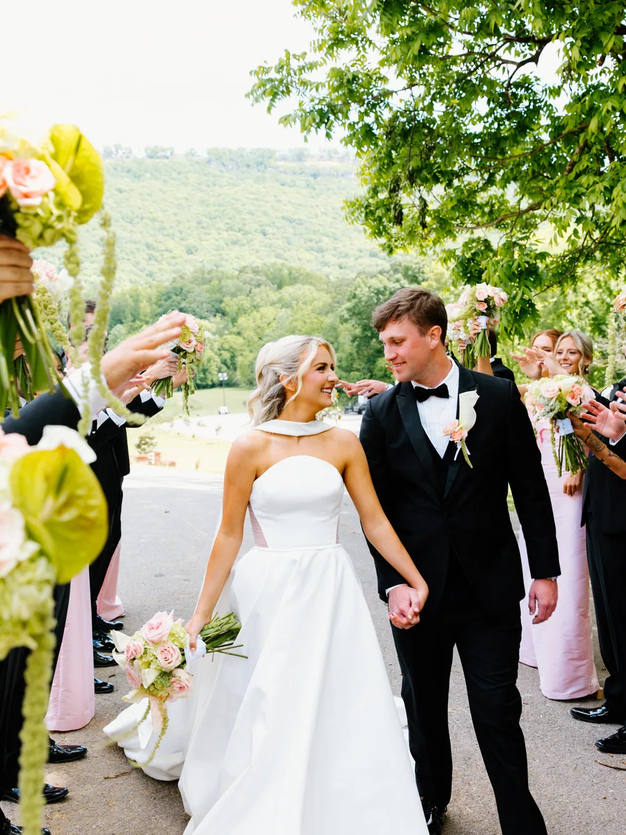 The wedding party throwing petals over the couple