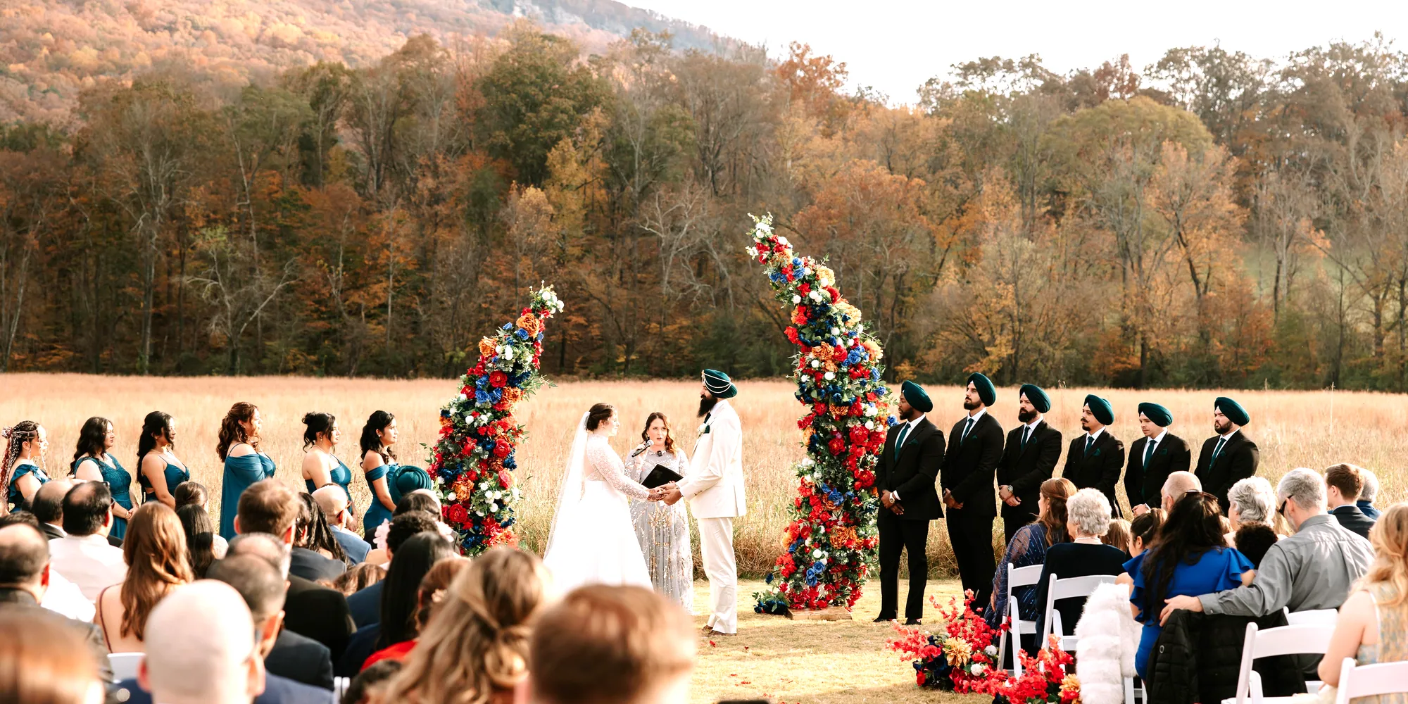 Caitlin and Gupinder at the altar in the meadow, the wedding party either side