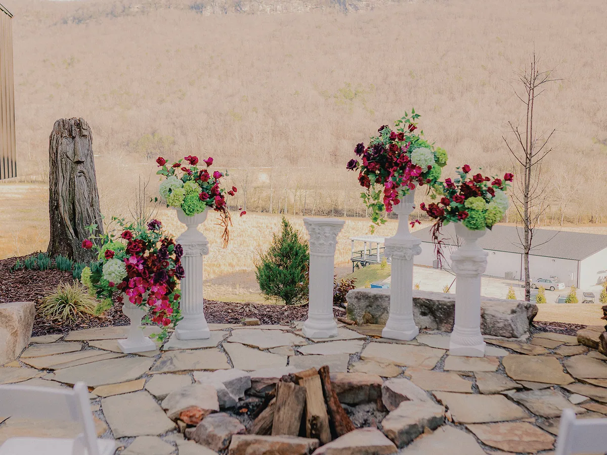 The fire pit lit at golden hour, florals on either side