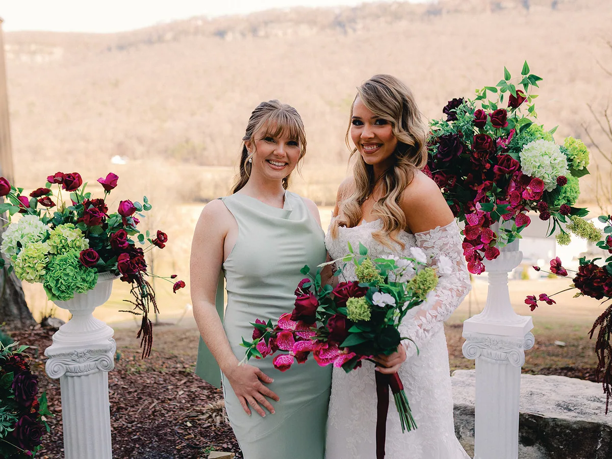 Bridesmaids beside tall floral arrangements at golden hour